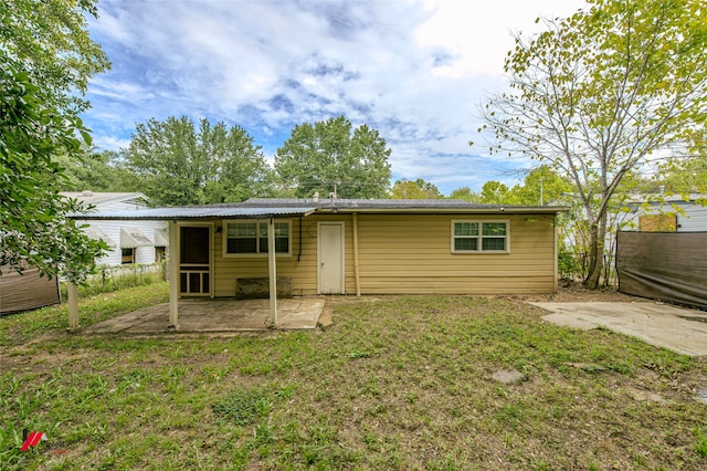 rear view of property featuring a lawn and a patio