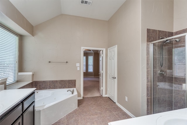 bathroom with vaulted ceiling, separate shower and tub, vanity, and a wealth of natural light