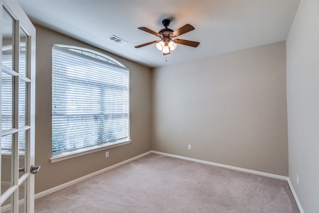 carpeted spare room featuring ceiling fan