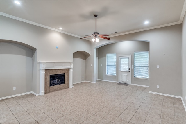 unfurnished living room with light tile patterned floors, a fireplace, ornamental molding, and ceiling fan