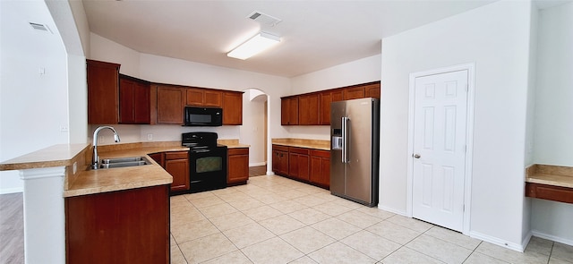 kitchen featuring black appliances, kitchen peninsula, light tile patterned flooring, and sink