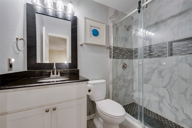 bathroom featuring a shower with shower door, vanity, and toilet