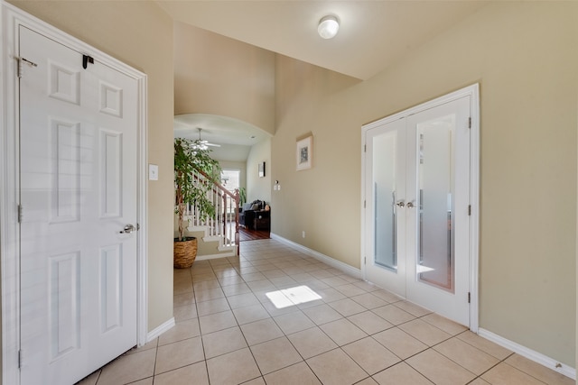 tiled entryway featuring ceiling fan and french doors