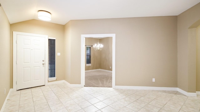 tiled entryway featuring lofted ceiling and a notable chandelier