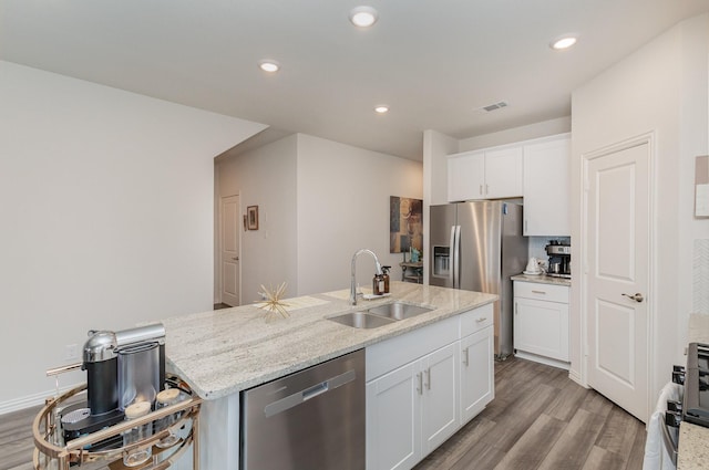 kitchen featuring white cabinets, sink, light stone countertops, appliances with stainless steel finishes, and light hardwood / wood-style floors