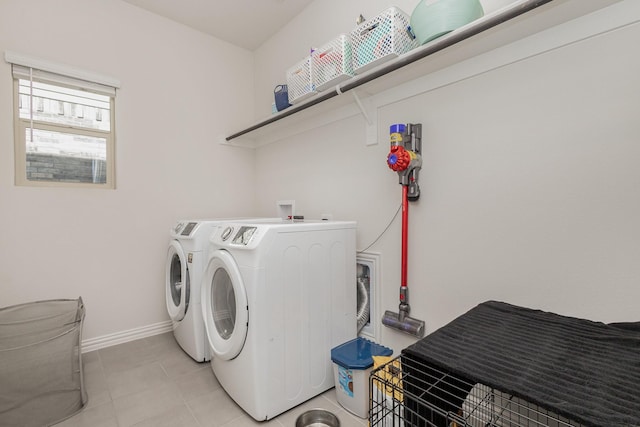 clothes washing area featuring washing machine and clothes dryer and light tile patterned flooring