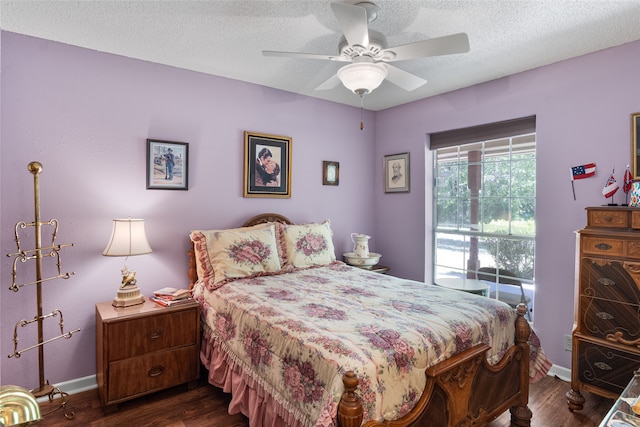 bedroom with a textured ceiling, dark wood-type flooring, and ceiling fan