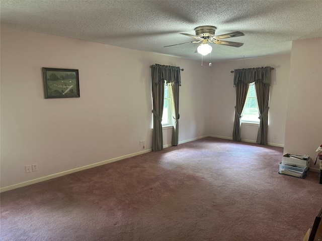 carpeted spare room featuring ceiling fan and a textured ceiling