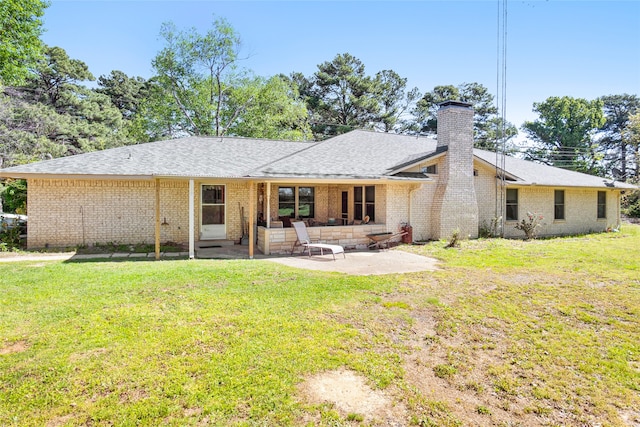 rear view of property featuring a yard and a patio area