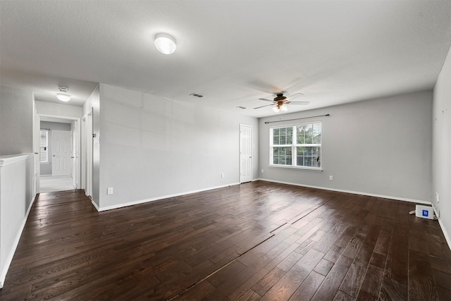 empty room with dark hardwood / wood-style floors and ceiling fan