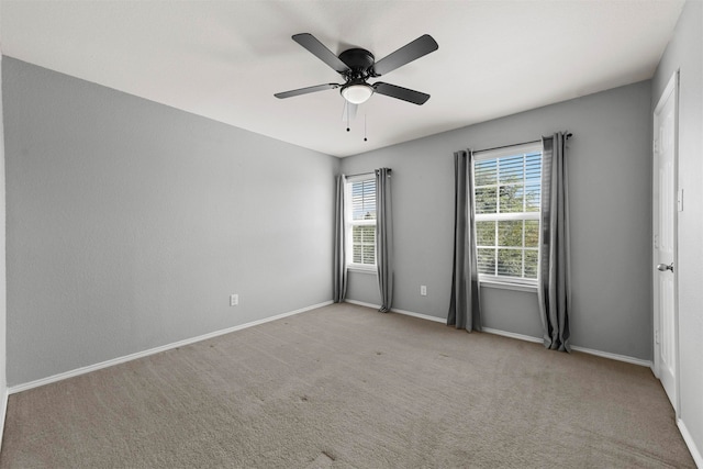 carpeted spare room featuring ceiling fan