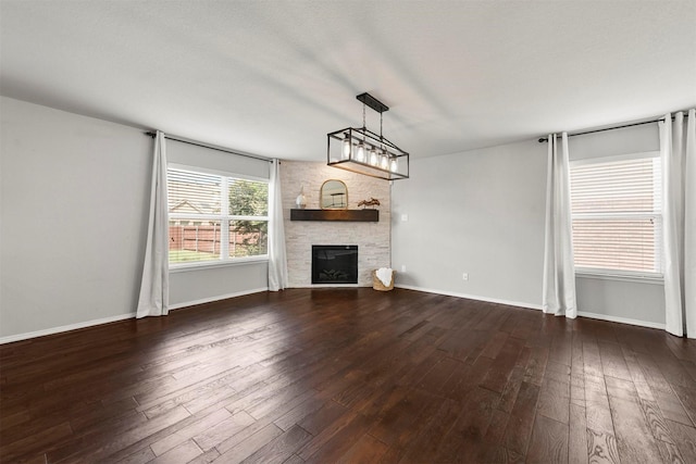 unfurnished living room featuring ceiling fan and dark wood-type flooring