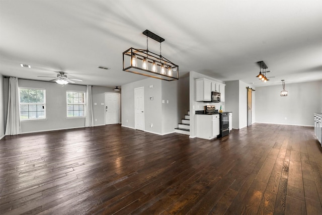 kitchen featuring sink, dark hardwood / wood-style flooring, decorative light fixtures, white cabinets, and black appliances