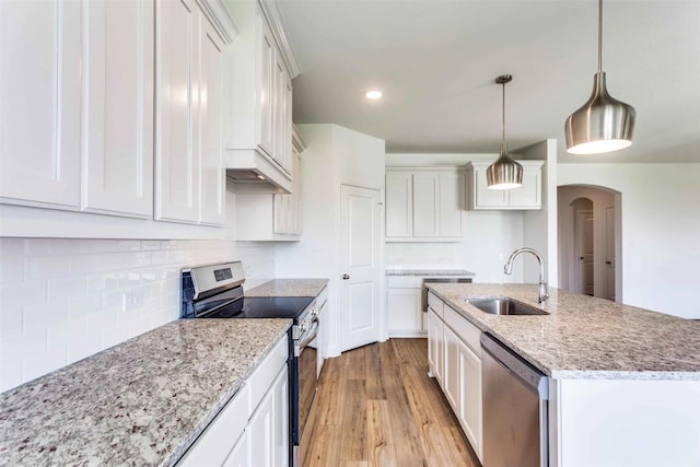 kitchen featuring decorative light fixtures, appliances with stainless steel finishes, sink, and white cabinetry