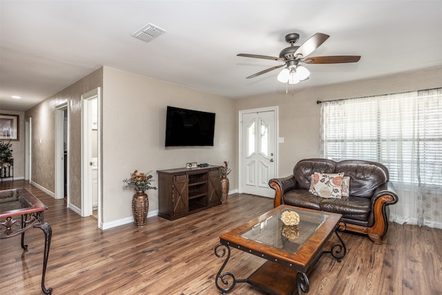 living room featuring ceiling fan and dark hardwood / wood-style floors