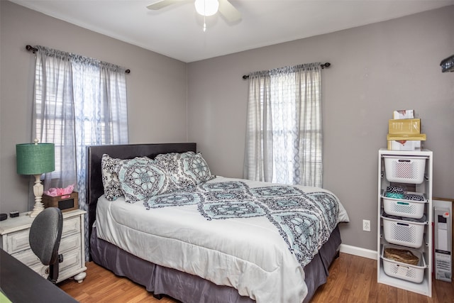 bedroom with hardwood / wood-style floors, multiple windows, and ceiling fan