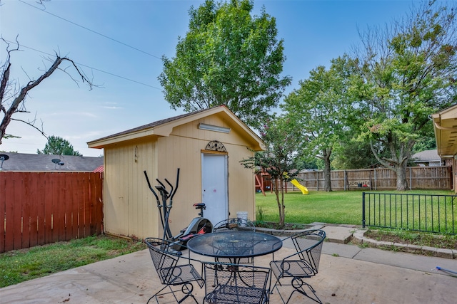 view of patio / terrace featuring a playground and a storage shed