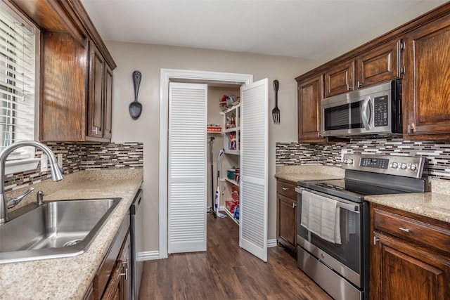 kitchen featuring stainless steel appliances, dark hardwood / wood-style floors, sink, and tasteful backsplash