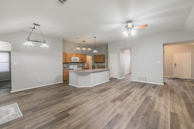 kitchen featuring white appliances, visible vents, open floor plan, brown cabinets, and decorative light fixtures