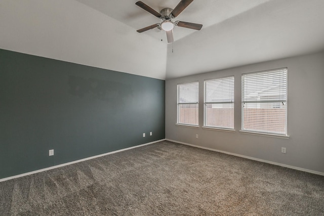 carpeted empty room with a ceiling fan, lofted ceiling, and baseboards