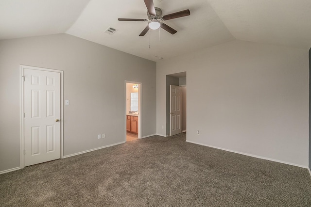 unfurnished bedroom featuring lofted ceiling, dark colored carpet, visible vents, connected bathroom, and baseboards