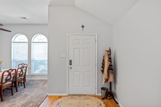 entrance foyer featuring light hardwood / wood-style floors, vaulted ceiling, and ceiling fan