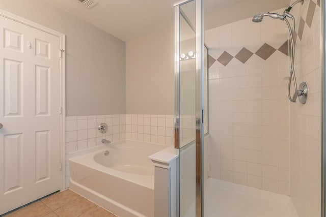 bathroom featuring a garden tub, a stall shower, and tile patterned floors