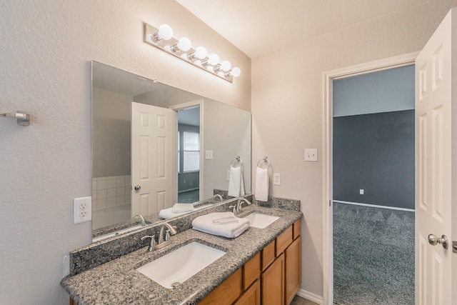 full bathroom with double vanity and a sink