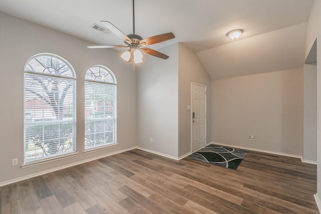 interior space with baseboards, visible vents, ceiling fan, wood finished floors, and vaulted ceiling