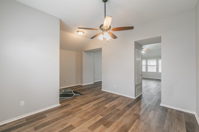 empty room with lofted ceiling, a ceiling fan, baseboards, and dark wood-style flooring