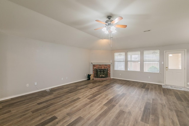 unfurnished living room with baseboards, visible vents, dark wood-style floors, ceiling fan, and a fireplace