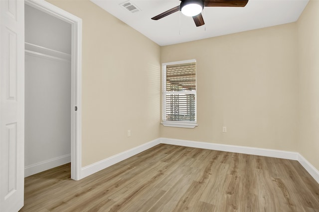 unfurnished bedroom featuring light wood-type flooring, ceiling fan, and a closet