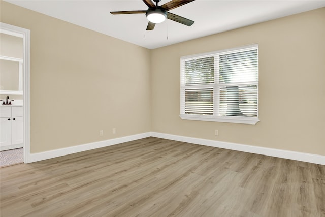 unfurnished room featuring light hardwood / wood-style floors, ceiling fan, and sink