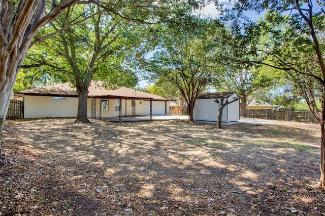 view of yard with a storage unit and a patio area