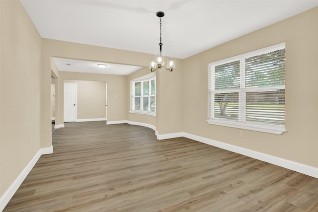 unfurnished dining area featuring hardwood / wood-style floors and a notable chandelier