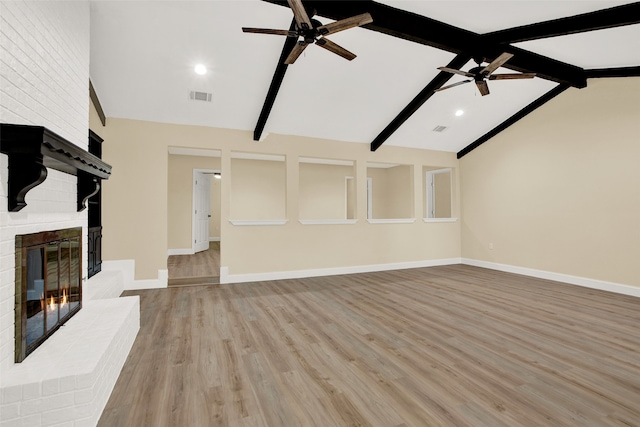 unfurnished living room featuring lofted ceiling with beams, light wood-type flooring, ceiling fan, and a fireplace