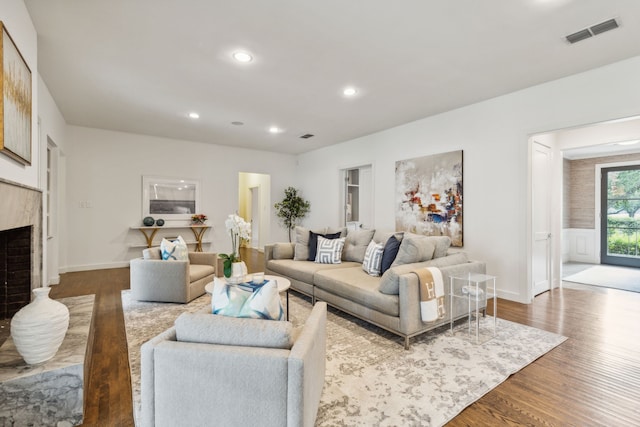 living room featuring wood-type flooring and a premium fireplace