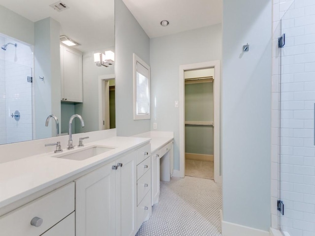 full bath with vanity, visible vents, baseboards, a spacious closet, and a stall shower