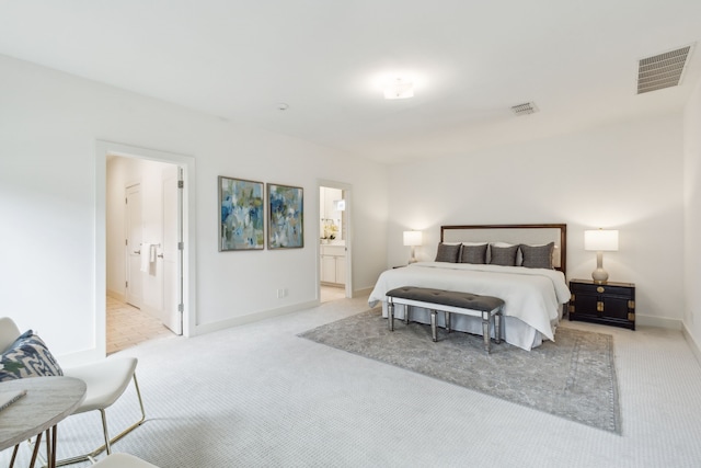 bedroom with light carpet and ensuite bathroom