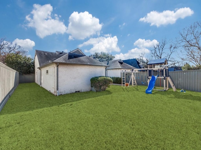 exterior space with a yard, brick siding, a playground, and a fenced backyard