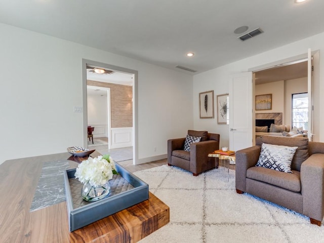 living area with recessed lighting, visible vents, a fireplace, and wood finished floors