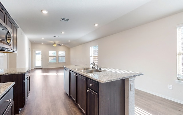 kitchen featuring stainless steel appliances, wood-type flooring, sink, and an island with sink