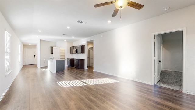 unfurnished living room with ceiling fan and dark hardwood / wood-style floors