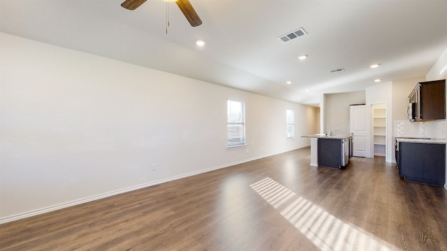 unfurnished living room with ceiling fan and dark hardwood / wood-style flooring