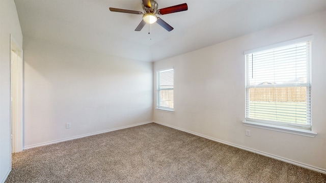 carpeted spare room featuring plenty of natural light and ceiling fan