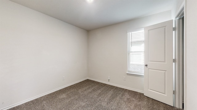 empty room featuring dark colored carpet