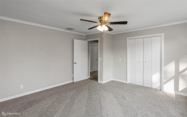 unfurnished bedroom featuring carpet, a closet, ceiling fan, and crown molding