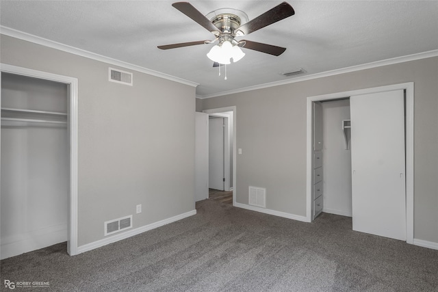 unfurnished bedroom featuring multiple closets, carpet floors, ceiling fan, and ornamental molding