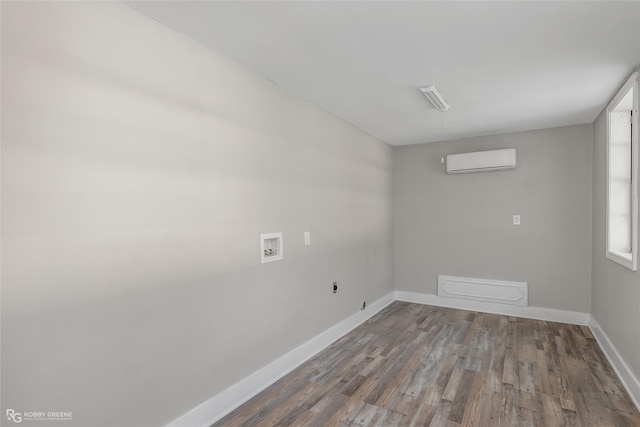 empty room with a wall unit AC and hardwood / wood-style floors