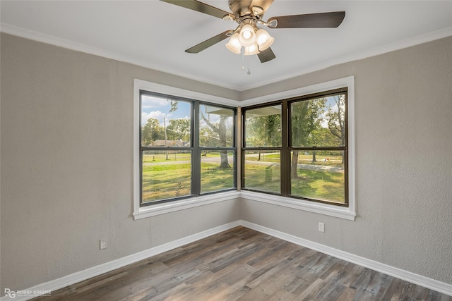 spare room with wood-type flooring, crown molding, ceiling fan, and a healthy amount of sunlight